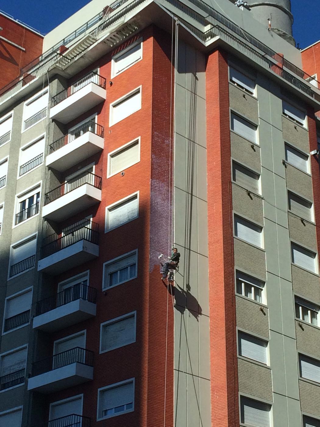 Pintor en silleta en edificio rojo y gris